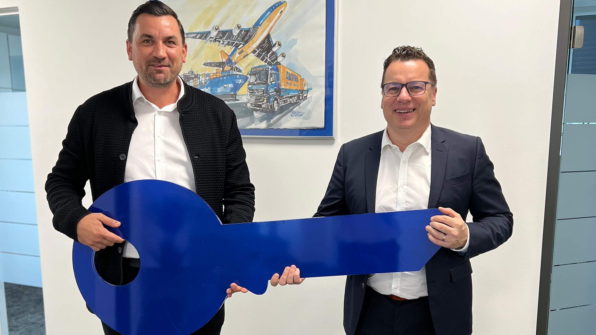 Rainer Mittl (rechts), Niederlassungsleiter DACHSER Austria Air & Sea Logistics Graz, erhält von Vermieter Peter Schreiner den Schlüssel zum neuen Büro.